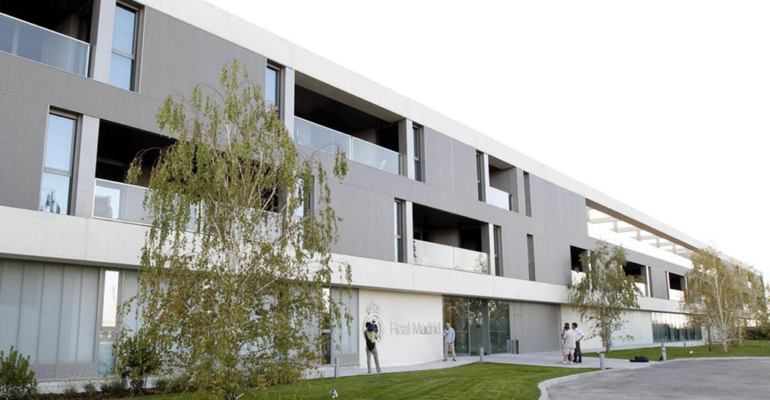 GRA414. MADRID, 26/09/2013.- Fachada de la residencia del primer equipo del Real Madrid en la Ciudad Deportiva de Valdebebas. El edificio, destinado a que las concentraciones y las horas de convivencia entre los futbolistas y el cuerpo técnico sean lo más amenas posible, cuenta con cincuenta y siete habitaciones individuales. Personalizadas todas ellas con el nombre de su inquilino, se agrupan en dos de las tres plantas del inmueble, 32 en la intermedia y 25 en la más alta. Similares en su diseño salvo la del entrenador, que tiene además un aparte para trabajar y reunirse, las estancias están equipadas con lo último en tecnología y contienen terrazas que comparten cada dos personas. EFE/Ángel Díaz